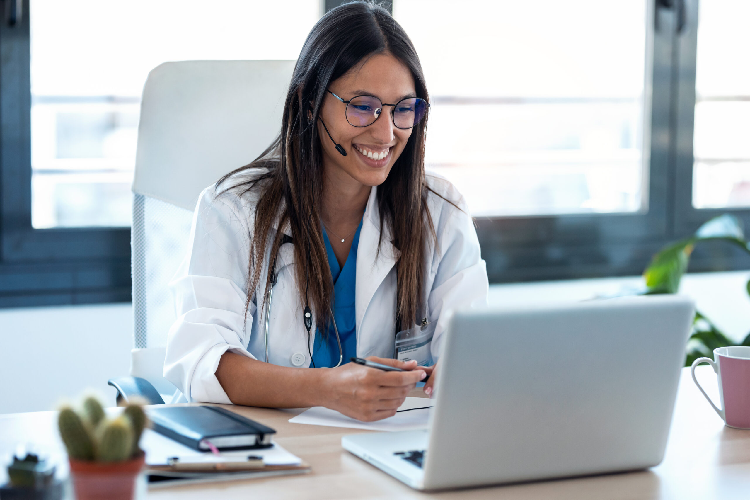 A licensed provider meeting with a patient by video from her desk